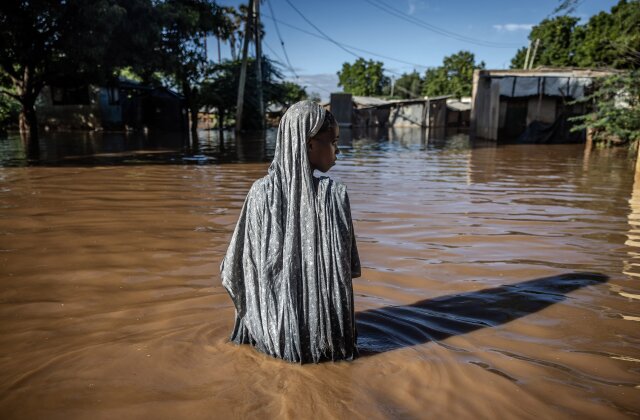Topshot - A woman wades through flood waters in a submerged residential area in Garissa, May 9, 2024.  Kenya is battling its worst flooding in recent history, the latest in a series of weather-related disasters scientists say are linked to the changing climate after weeks of heavy rain.  At least 257 people have died and more than 55,000 homes have been displaced as dirty water has submerged entire villages, destroyed roads and flooded dams.  (Photo by Luis Tato/AFP) (Photo by Luis Tato/AFP via Getty Images)